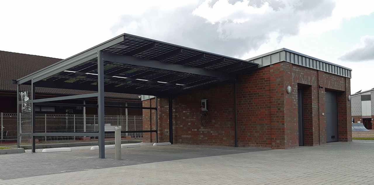 Gebäude mit Photovoltaik-Carport auf einem entwickelten Grundstück